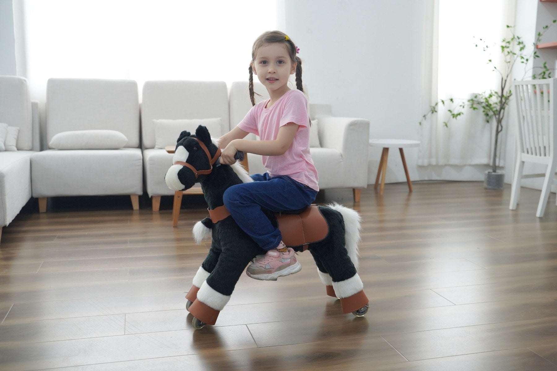 Child riding a real black ZEROOXRIDE plush horse indoors